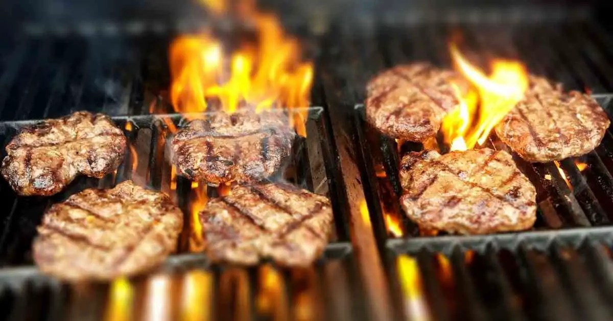 grilling burger patties on fire